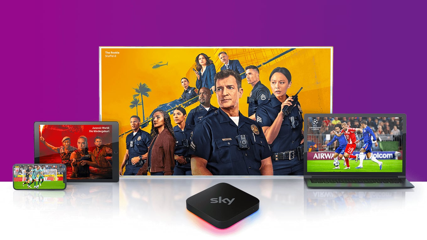 Sky Stream Box vor einem Fernseher, der das Sky Stream UI zeigt, versetzt dahinter zwei weitere Fernseher, die Inhalte von Sky zeigen.